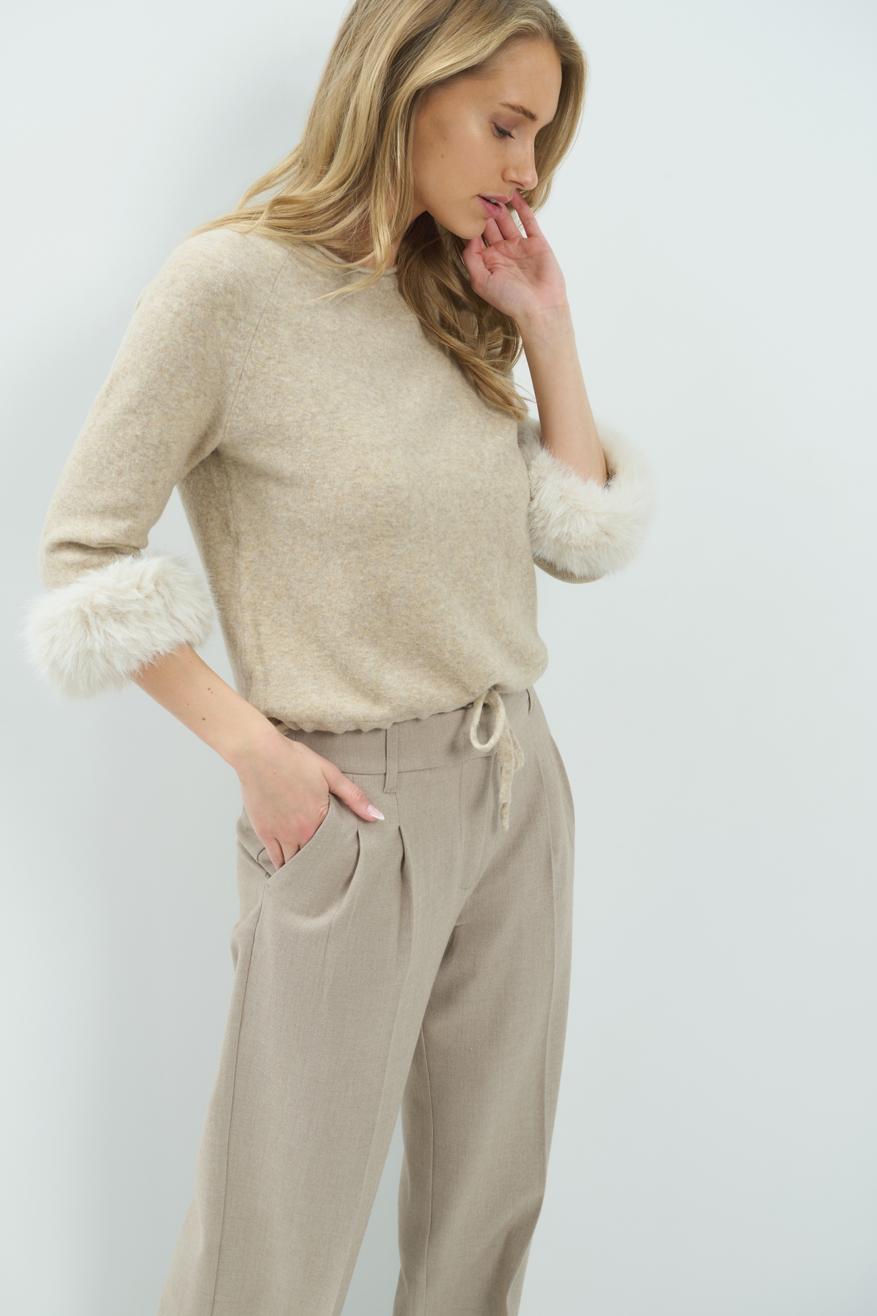 Model in een fijnbrei trui van YAYA met afneembare manchetten in light beige melange