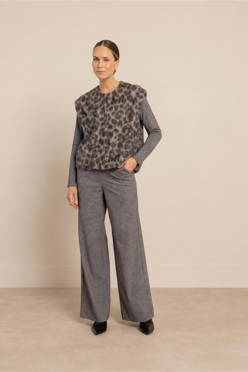 Model in de grijze travel broek Lexie van Studio Anneloes, gecombineerd met de bodywarmer met luipaardprint van Emily van den Bergh