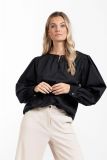 Poplin blouse met ronde hals met parelknoopje, cuffs aan de lange bloesende mouwen en losse fit van het merk Studio Anneloes in de kleur zwart.