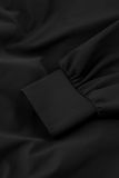 Zwarte jumpsuit van travel stof met overslag, lange mouwen met boorden, wijde pijpen en steekzakken van het merk Studio Anneloes.