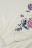 Fijnbrei trui met boorden, lange mouwen met bloemen van pailletten en ronde hals van het merk Studio Anneloes in de kleur gebroken wit.