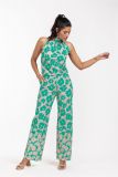 Mouwloze travel jumpsuit met bloemenprint, hoge strikhals, wijde pijpen en steekzakken van het merk Studio Anneloes in de kleur clay/smaragd.