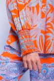 Blouse met print van het merk Emily van den Bergh met V-hals en lange mouwen met gesmockte borden in de kleur oranje.
