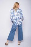 Blouse van het merk Emily van den Bergh met all-over letterprint, lange mouwen, knoopsluiting en blousekraag in de kleur blauw.
