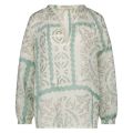 De Josephine blouse van het merk Nukus heeft een allover print, een V hals met kwastjes eraan en lange mouwen in de kleur aqua.